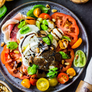 Tomate-Mozzarella mal anders: Cremiger Büffelmozzarella und eine aromatische Tomatenvielfalt, garniert mit frischem Basilikum, fruchtigem Olivenöl und dem besten Balsamico: Rezept für Caprese-Salat, der den Klassiker Tomate-Mozzarella auf eine ganz hohe Stufe stellt. - kaloriengeniessen.de #caprese #tomate-mozzarella #salat #balsamico #mozzarella #burrata #insalata #salad #schnell #einfach #kalorienarm #kaloriengeniessen #rezeptezumabnehmen #kalorienarmkochen