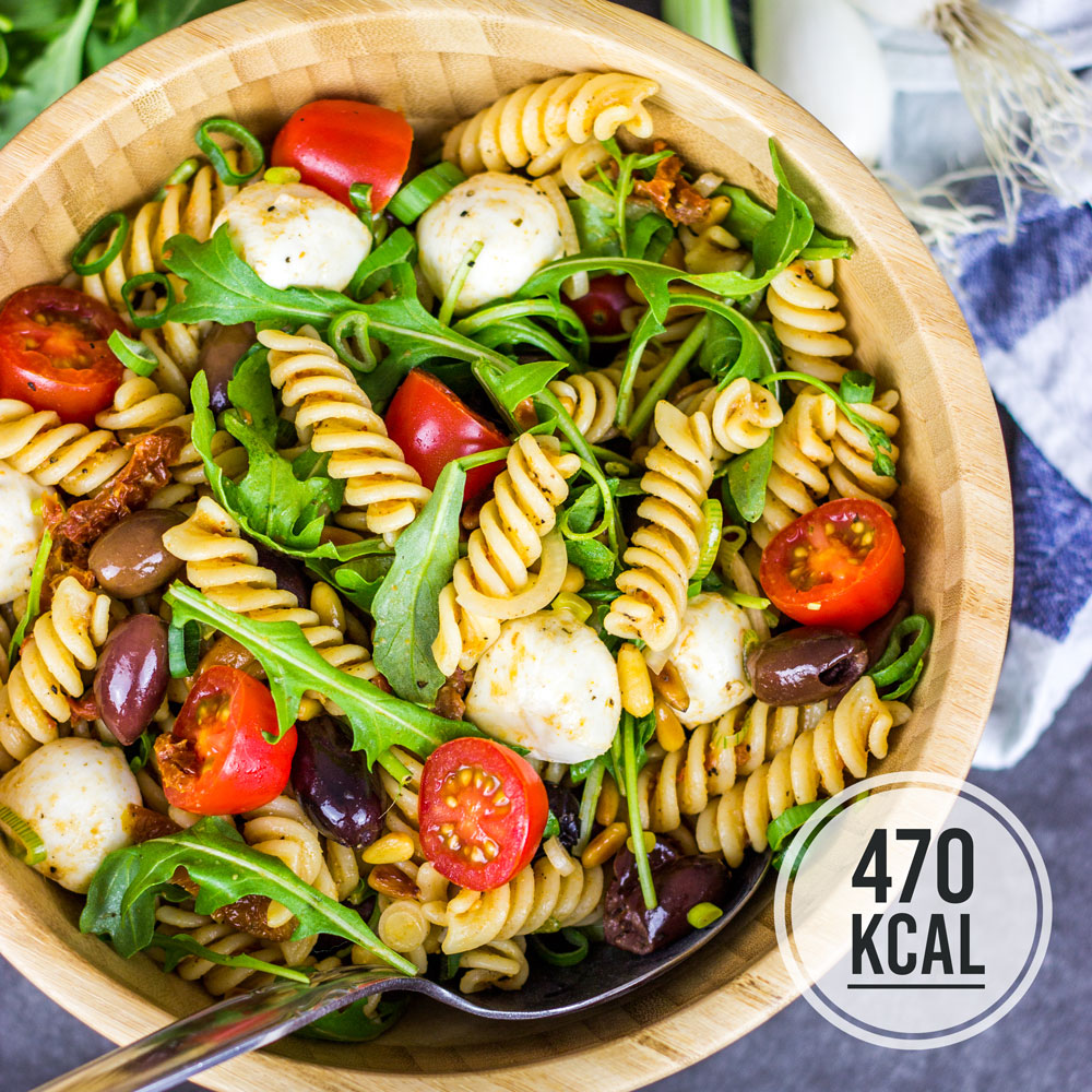 Leichter kalorienarmer Nudelsalat italienischer mit Pesto, Rucola und Mozzarella (vegetarisch und perfekt zum Grillen). Toller Sommersalat ohne Mayonnaise. Lässt sich mit Oliven, getrockneten Tomaten, frischen Tomaten, Rucola, Babyspinat, Mozzarella, Feta und Pinienkernen nach Geschmack abwandeln. Rucola erst kurz vor dem Essen dazugeben, damit er knackig bleibt. Fettarm und gesund. Gesundes und kalorienarmes Kochen. Schnelle und einfache Rezepte zum Abnehmen. - kaloriengeniessen.de #salat #nudelsalat #italienisch #pesto #machtsatt #mittagessen #rucola #mozzarella # fusilli #Grillen #kalorienarm #gesund #kalorienarmerezepte #kaloriengeniessen #rezeptezumabnehmen